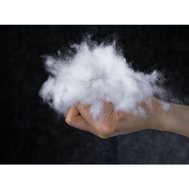 Fione Floral Tufted Cushion - Ivory - 9 - Hand holding fluffy white cotton, dark background, close-up view, person's hand