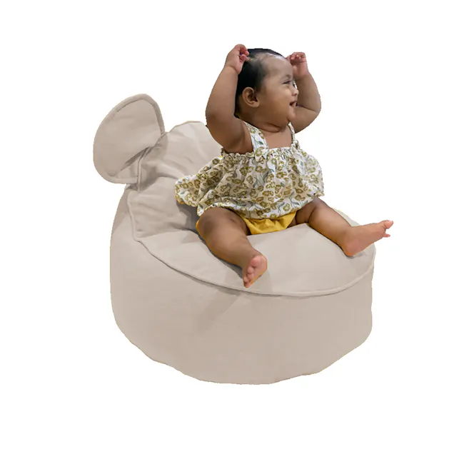 Eddy Bean Bag - Grey - 2 - Baby sitting on plush, beige bean bag chair, wearing floral dress, arms raised, joyful