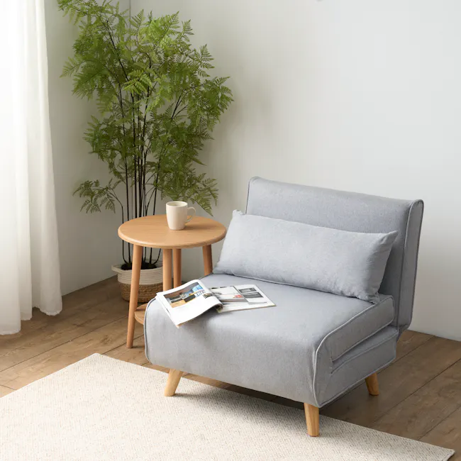 Noel Sofa Bed - Harbour Grey - 3 - Light gray sofa, wooden legs, light blue cushions, white coffee mug, round wooden table