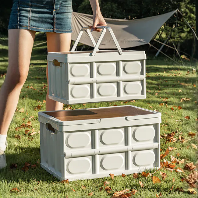 Blake Foldable Storage Box - Military Green - 5 - woman holding two white plastic storage bins outdoors, grassy area with