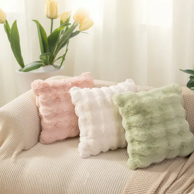 Luxe Faux Fur Cushion - White - 3 - Soft, pastel-colored pillows in pink, white, and green, placed on a cozy beige couch