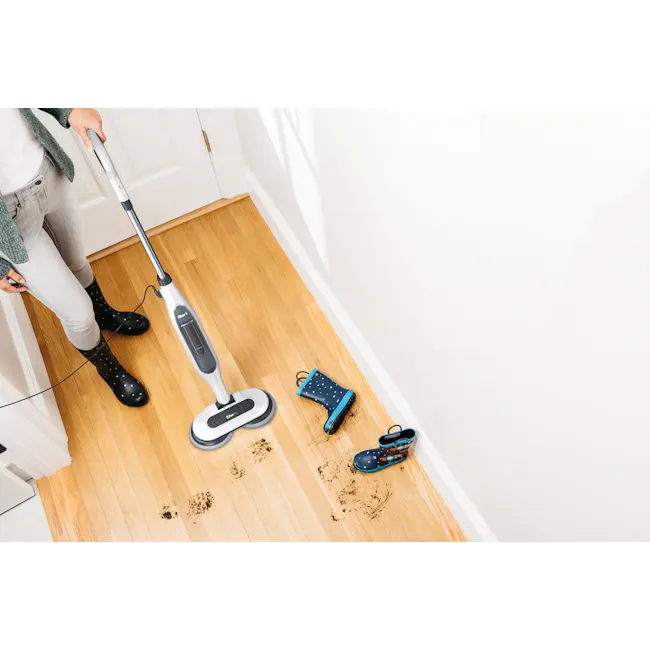 Shark Steam and Scrub Mop - 5 - person using vacuum cleaner, wooden floor, black boots, blue shoes, dark stains, white door