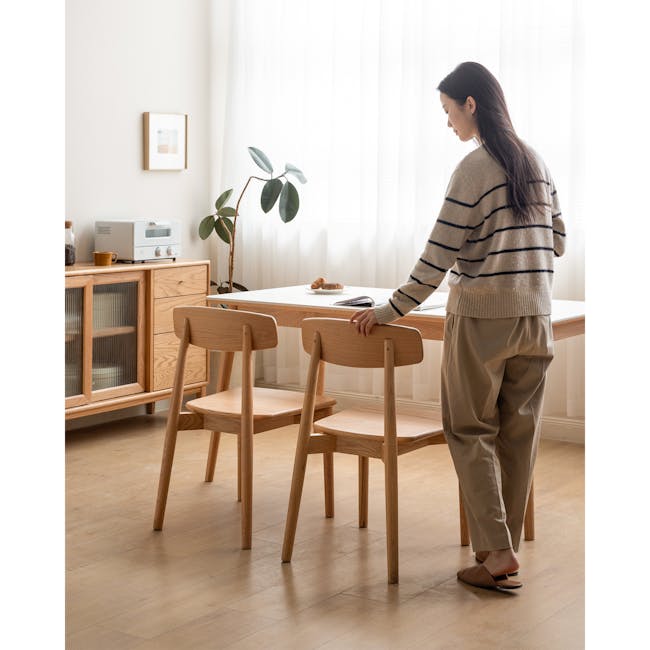 Solis Dining Chair - Oak - 2 - Light streaming through sheer curtains, cozy wooden dining room, minimalist kitchen setup