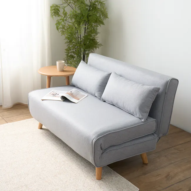 Noel 2 Seater Sofa Bed - Harbour Grey - 7 - Light gray sofa, wooden legs, light beige carpet, white curtains, indoor plant