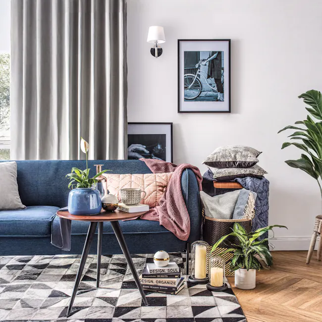 Coati Wall Lamp - White - 2 - Modern living room, cozy seating, blue sofa, textured pillows, geometric rug, abstract art