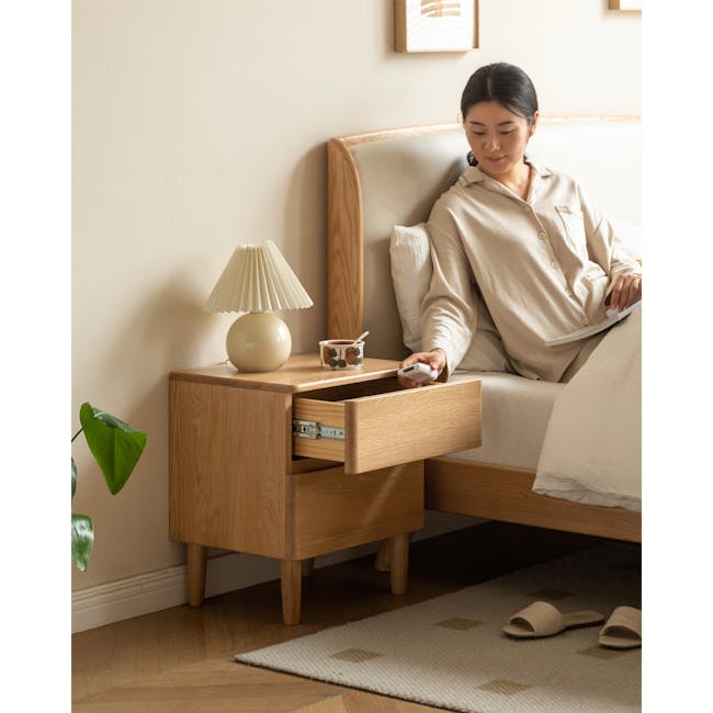 Nova King Storage Bed in Beige Boucle with 2 Natalia Bedside Table - 21 - Sitting on bed, woman reading, using tablet