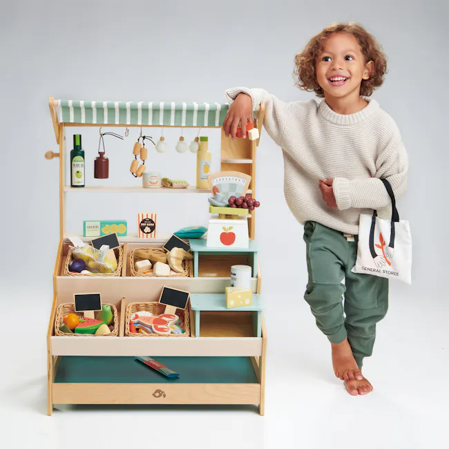 Tender Leaf Toy Kitchen - General Stores - 7 - Wooden toy kitchen set, child's hand resting on shelf, olive oil bottle