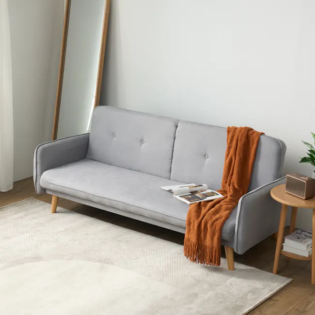 Emery 3 Seater Sofa Bed - Pigeon Grey - 5 - Light gray sofa, wooden legs, white and beige rug, orange throw blanket, modern
