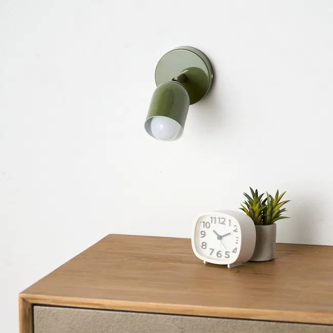 Hetta Wall Light - Green - 3 - Green wall-mounted lamp, white clock, wooden table, potted plant, minimalist decor, natural