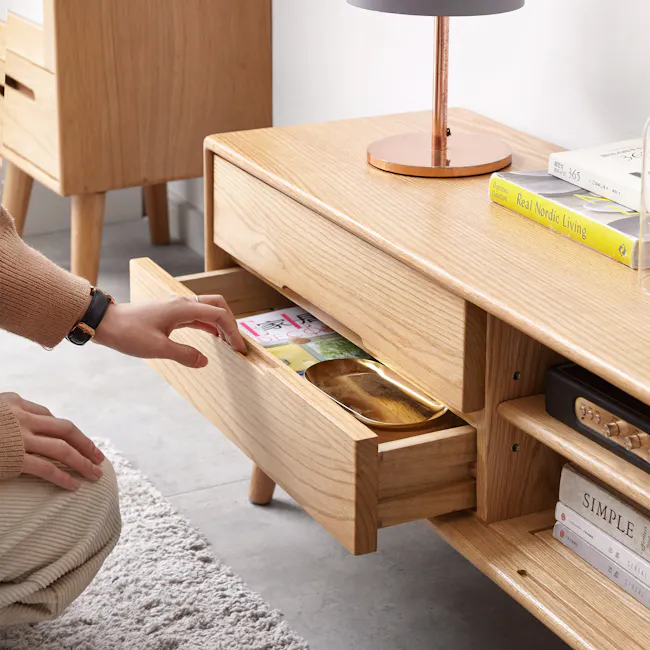 Beau TV Console 1.5m - Oak - 3 - Wooden side table, drawer opening, person's hand, beige sweater, watch, wooden floor