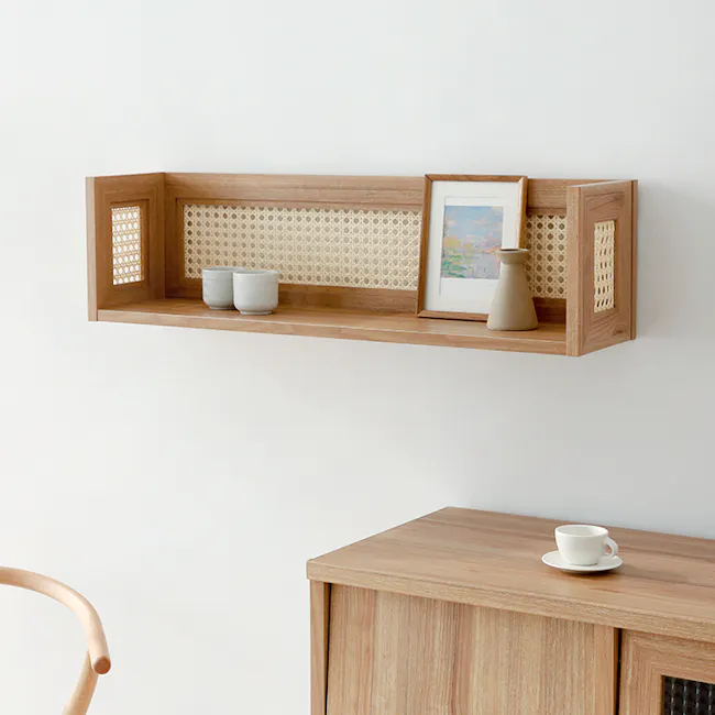 Belig Rattan Wall Shelf - Oak - 3 - Wooden shelf with woven backrest, white ceramic cups, light brown vase, framed picture