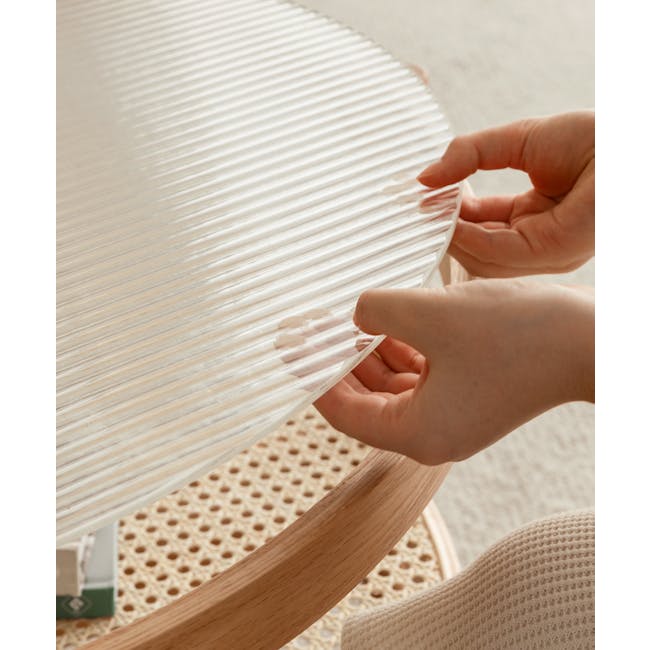 Lilian Rattan Coffee Table - Natural (Glass Tabletop) - 10 - Wooden table, person's hands, transparent sheet, crafting