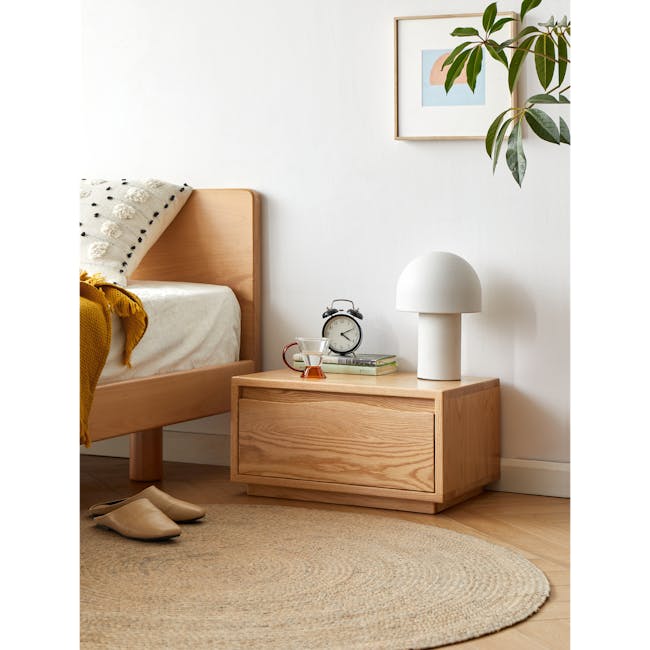 Elias Low Bedside Table - 3 - Wooden nightstand, beige slippers, woven rug, wooden dresser, white lamp, yellow throw