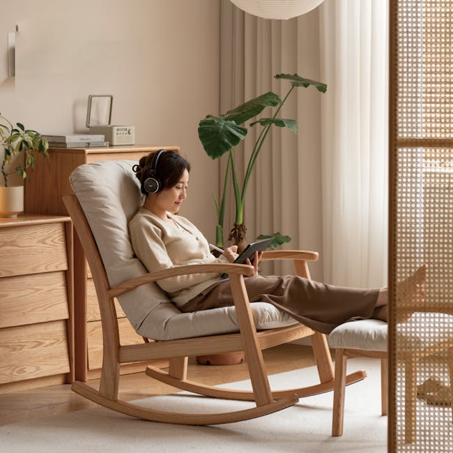 Kusa Rocking Lounge Chair with Ottoman - 4 - Wooden rocking chair, woman wearing headphones, tablet in hand, beige sweater