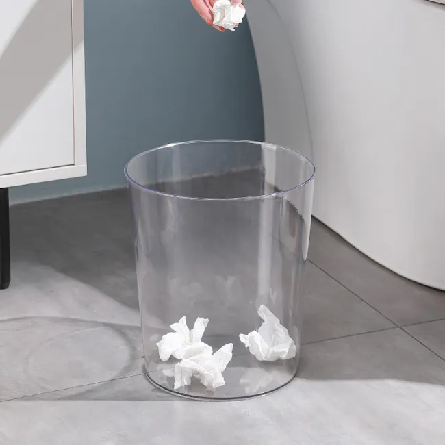 Gabri Waste Bin - 3 - Clear plastic trash can, crumpled tissues, white paper, indoor setting, person holding tissues, white