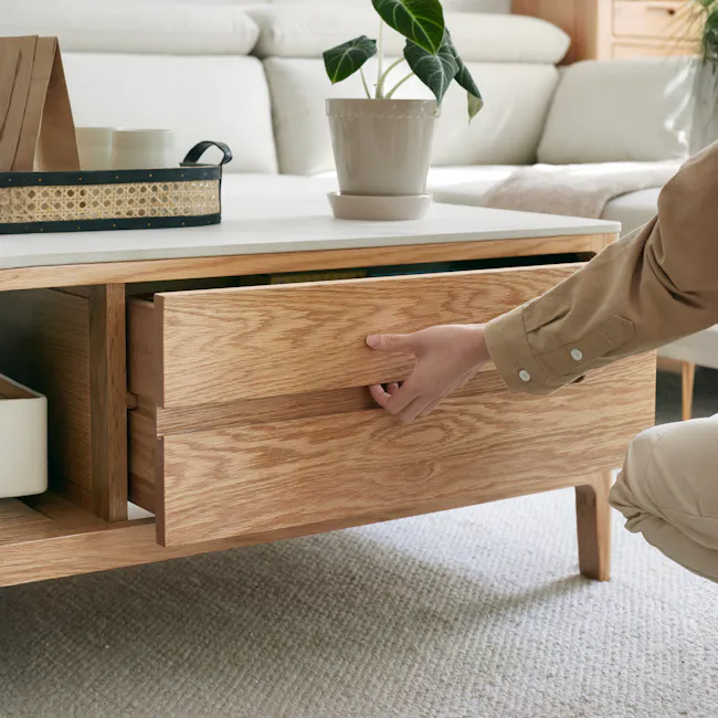 Devin Coffee Table 1.2m (Sintered Stone) - 12 - Wooden drawer, beige carpet, light brown wooden floor, beige pants, person's