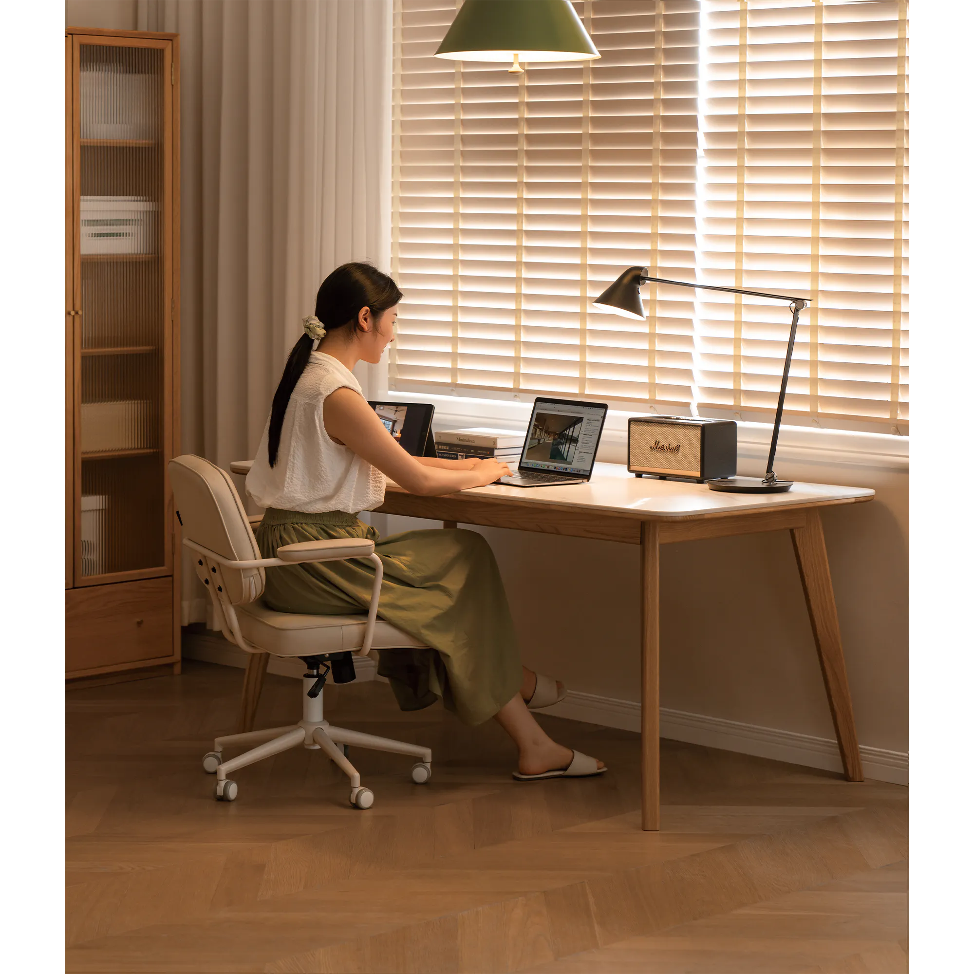 Nellie Dining Table 1.4m - Oak (Sintered Stone) - 9 - Wooden desk, laptop, woman working, green lamp, blinds, beige