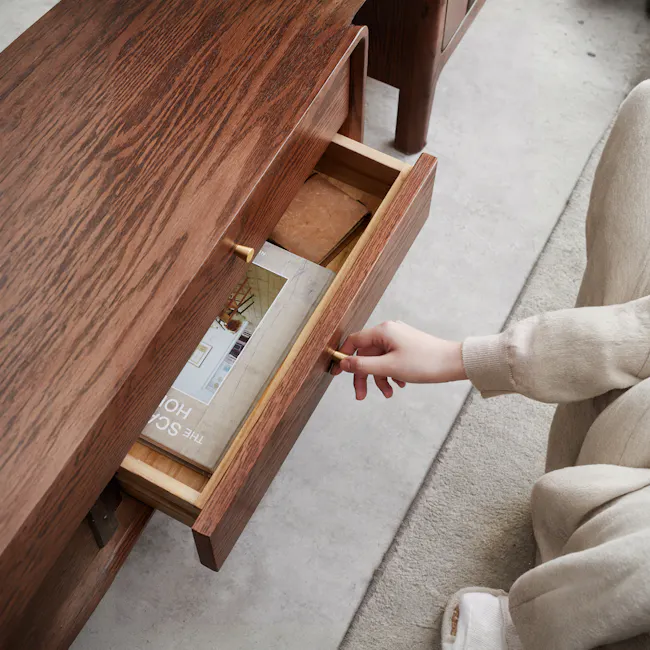 Lucia TV Console 2m - 4 - Wooden drawer, open drawer, person's hand, beige sweater sleeve, floor, light-colored carpet