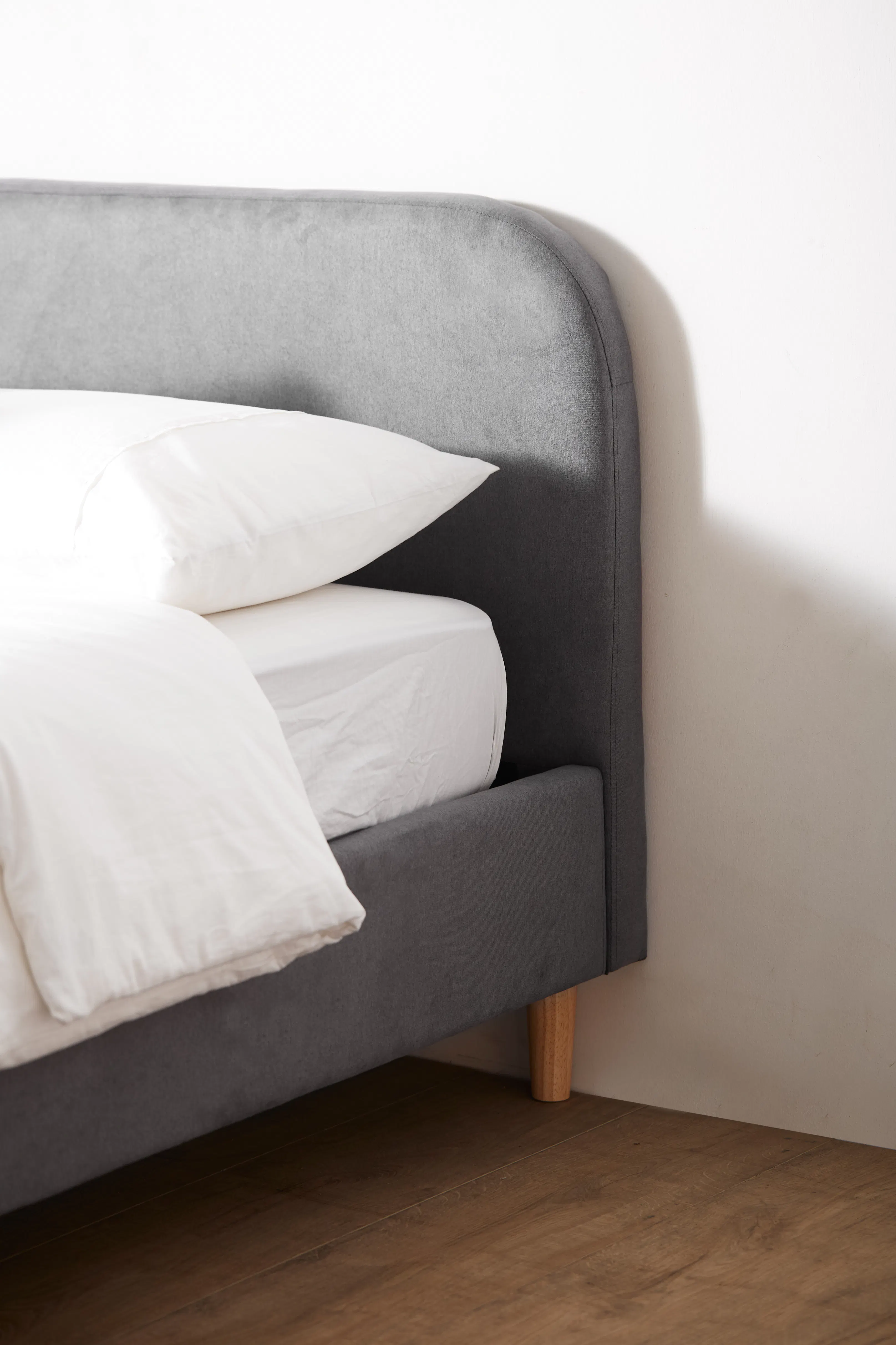 Nolan Single Bed - Hailstorm - 12 - Grey upholstered headboard, white pillows, wooden floor, minimalist design, soft