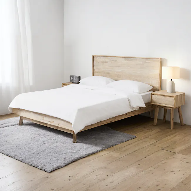Leland King Bed - 2 - Wooden bed frame, white bedding, wooden nightstands, gray rug, light wooden flooring, natural light