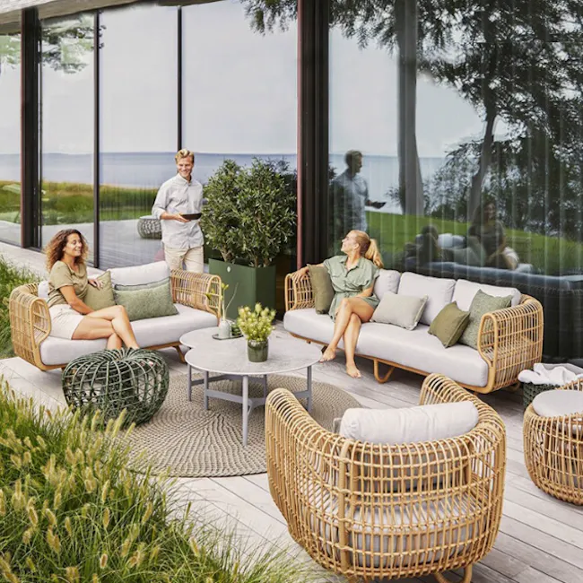 Soleil 2 Seater Outdoor Sofa - 13 - Modern outdoor living area with large glass windows, featuring wicker furniture