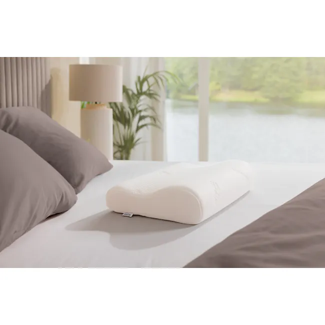 TEMPUR® Original Pillow (4 Sizes) - 6 - White mattress with textured design, neatly arranged pillows, soft lighting, serene