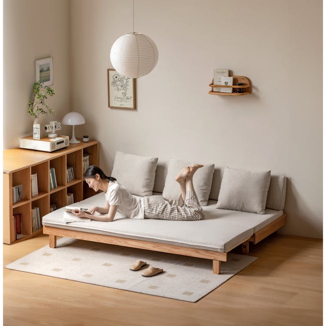 Reese 3 Seater Sofa Bed - Oak, Off White - 7 - Minimalist living room, cozy seating area, person reading, modern furniture
