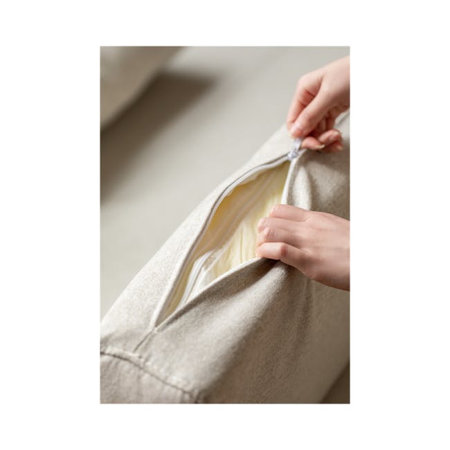 Reese 3 Seater Sofa Bed - Oak, Off White - 12 - Close-up of a person's hands opening a beige fabric bag, revealing a yellow