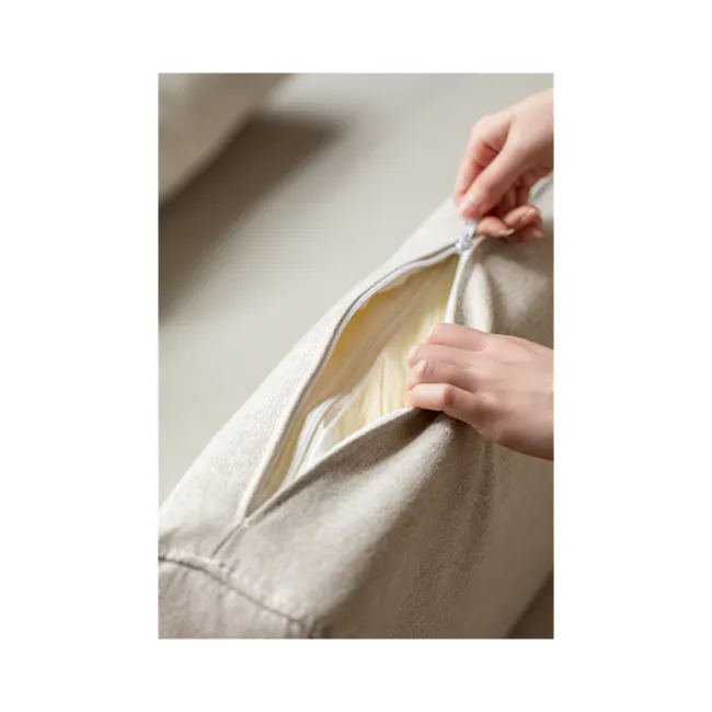 Reese 3 Seater Sofa Bed - Oak, Off White - 12 - Close-up of a person's hands opening a beige fabric bag, revealing a yellow