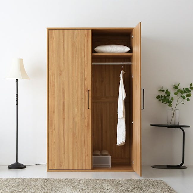 Mirans 2 Door Wardrobe - Oak - 7 - Wooden wardrobe with open doors, white pillow on top, hanging white towel, neatly folded
