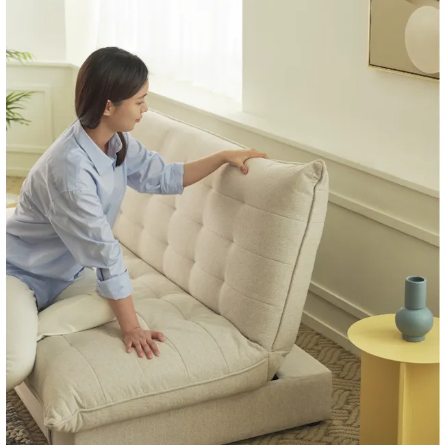 Tessa Storage Lounge Sofa Bed - Beige (Eco Clean Fabric) - 10 - Light-colored, modern sofa, woman sitting on it, hand