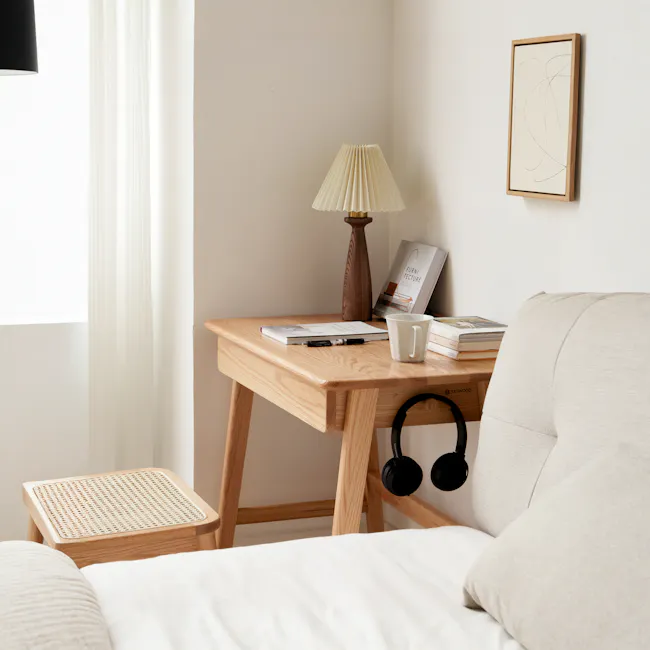 Chase Study Table 1m - 11 - Wooden desk, beige lamp, white cup, books, headphones, beige cushion, light-colored wall