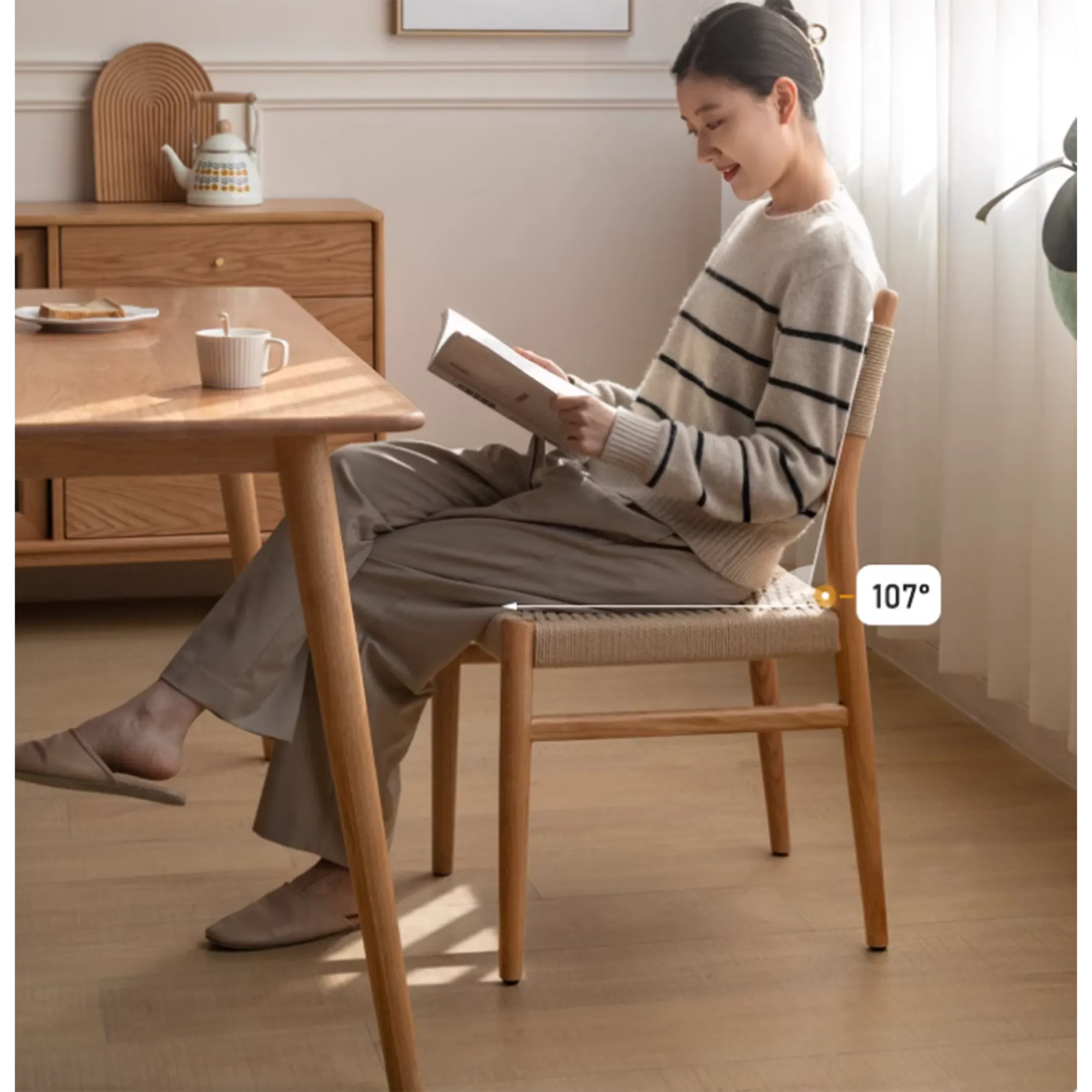 Lucille Dining Chair - 9 - Woman reading a book in a cozy room, Minimalist interior with natural light, Wooden furniture and
