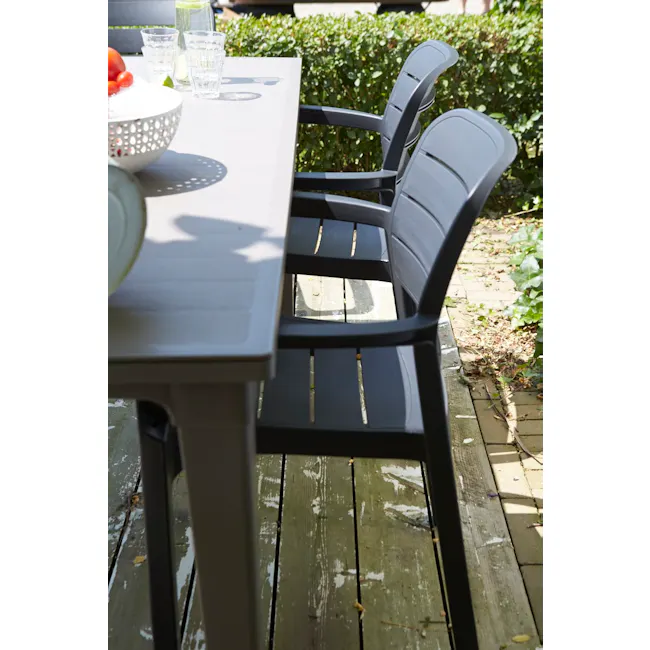 Tisara Chair - Graphite - 3 - Outdoor patio furniture, black metal chairs, wooden deck, green foliage, sunny day, outdoor