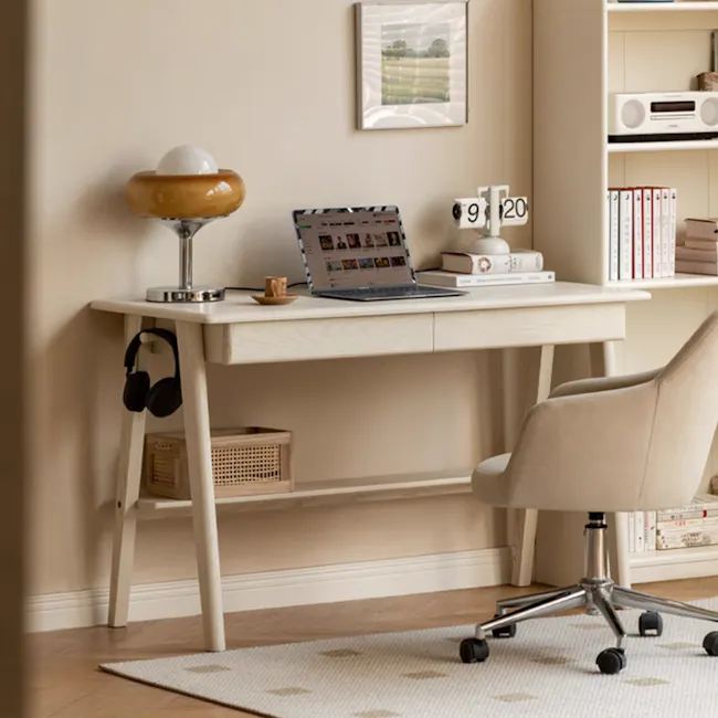 Zion Study Table 1m - 2 - Laptop on desk, beige chair, white desk, wooden desk legs, soft lighting, bookshelf, headphones