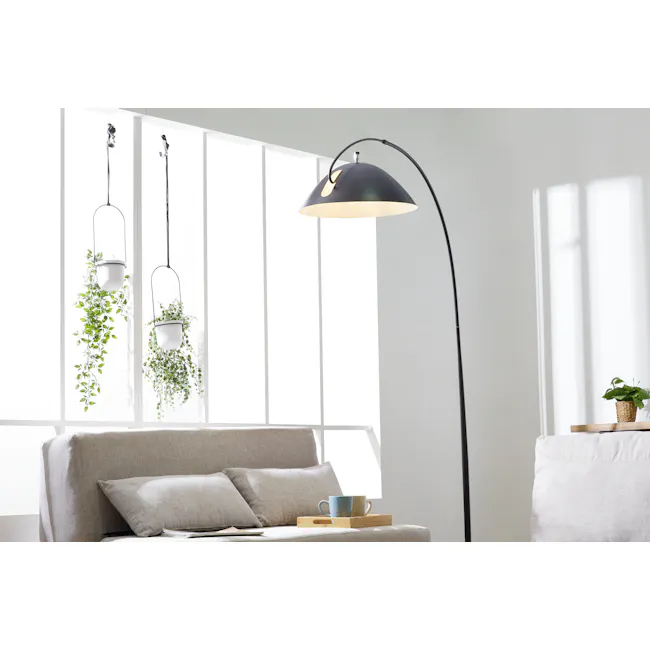Jimmi Arched Floor Lamp - 2 - Modern minimalist living room, bright natural light, white walls, hanging plants, contemporary
