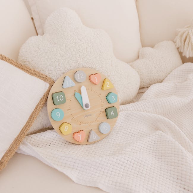 Bubble Wooden Clock with Shapes - 2 - Soft, pastel-colored wooden toy clock with colorful numbers, placed on a cozy white