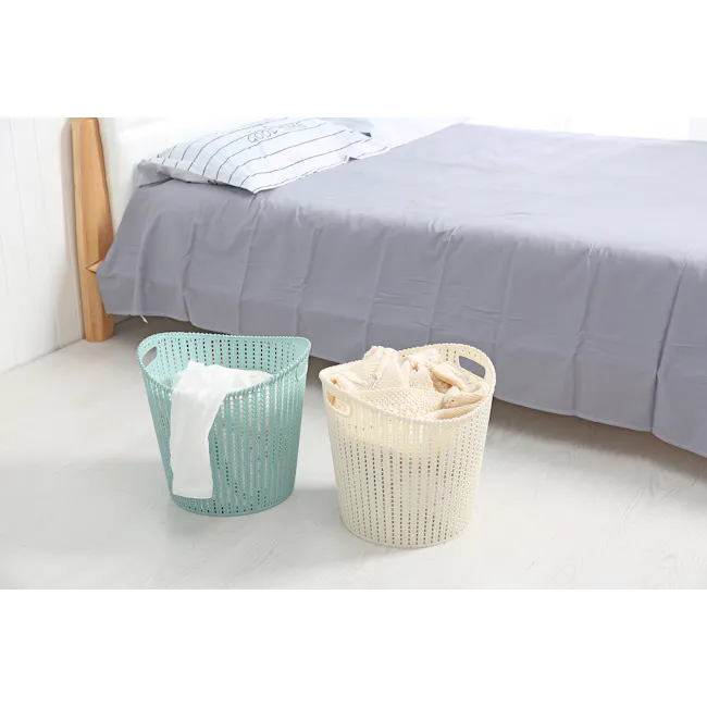 Alice Laundry Basket - White - 2 - Light gray bed with striped pillow, turquoise laundry basket with white garment, beige