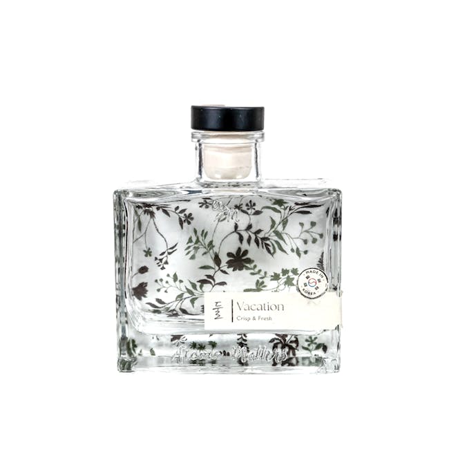 Aroma Matters Reed Diffuser - Vacation (2 Sizes) - 1 - Glass perfume bottle with floral design, clear liquid inside, floral