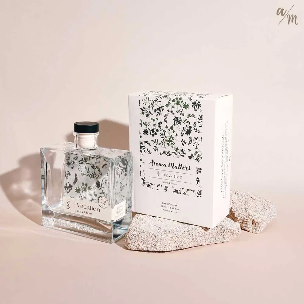 Aroma Matters Reed Diffuser - Vacation (2 Sizes) - 10 - Clear glass bottle with black cap labeled "Vacation, " floral