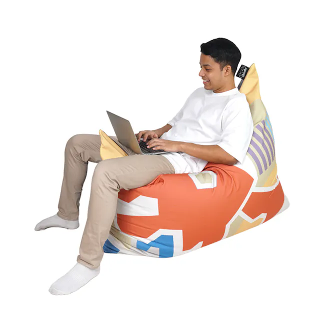 Doob Plopsta' Heritage Collection - Dragon Playground - 3 - white shirt, beige pants, orange bean bag, laptop, smiling