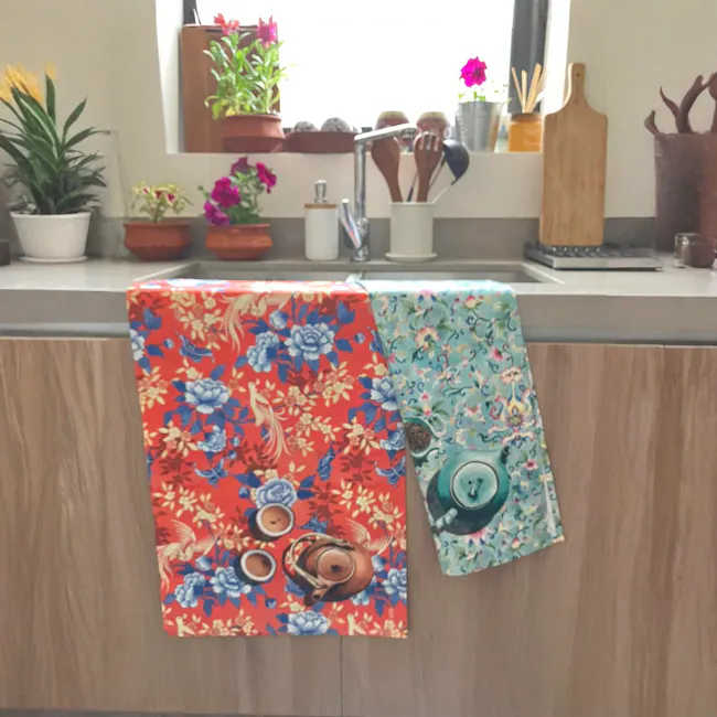 Singlapa Bird & Butterfly Tea Towel - 2 - Floral towel with vibrant red, blue, and yellow patterns hanging on kitchen