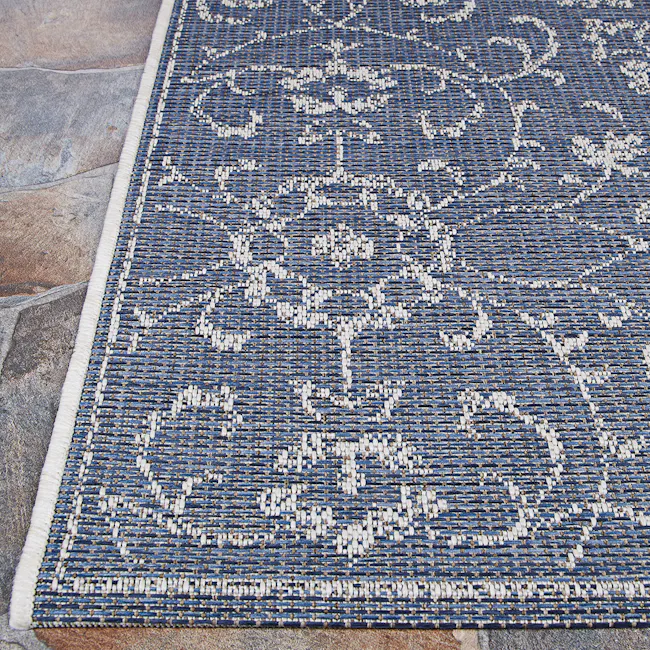 Summer Vines Flatwoven Rug - Navy Ivory (4 Sizes) - 4 - Blue woven rug with intricate white patterns, stone floor