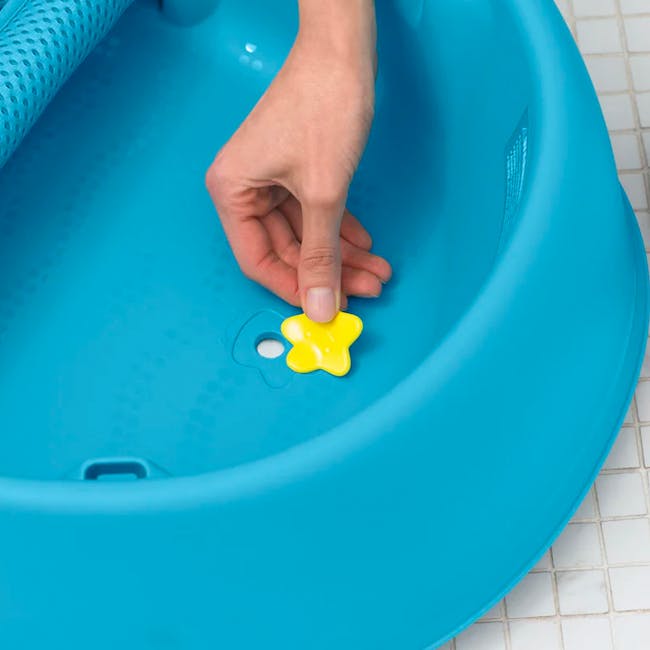 Skip Hop Moby Smart Sling 3 Stage Bath - Blue - 5 - Bathroom sink, blue plastic basin, yellow star-shaped object, hand