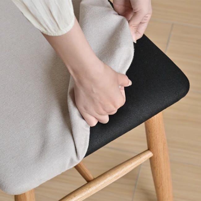 Xena Stool - Oak, Off White (Fabric) - 4 - Light-colored fabric, person's hands, adjusting cushion, wooden chair, minimalist