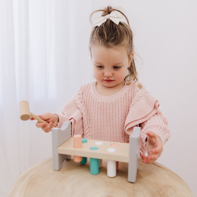 Bubble Wooden Hammer Bench - 6 - Cute girl with bow in hair, playing with wooden toy, pink knitted sweater, wooden mallet