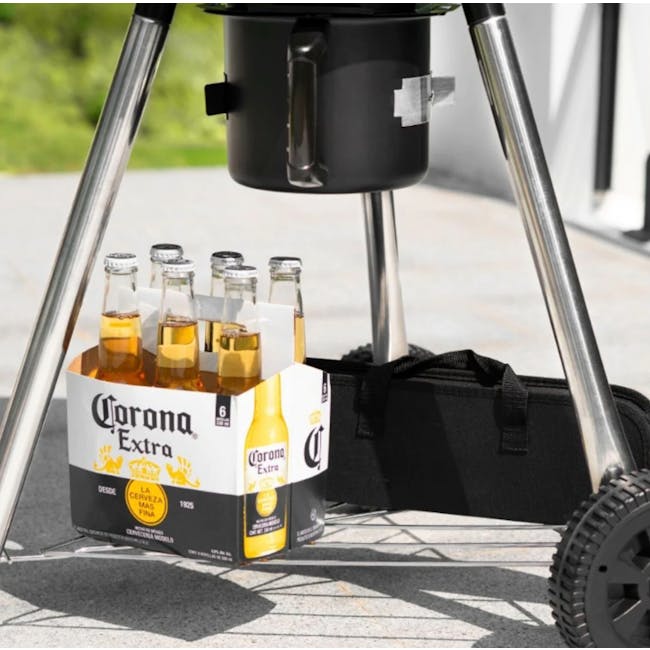 Flame Master Newton BBQ Grill - 5 - Portable camping grill with Corona Extra beer carton, outdoor patio setting, clear glass