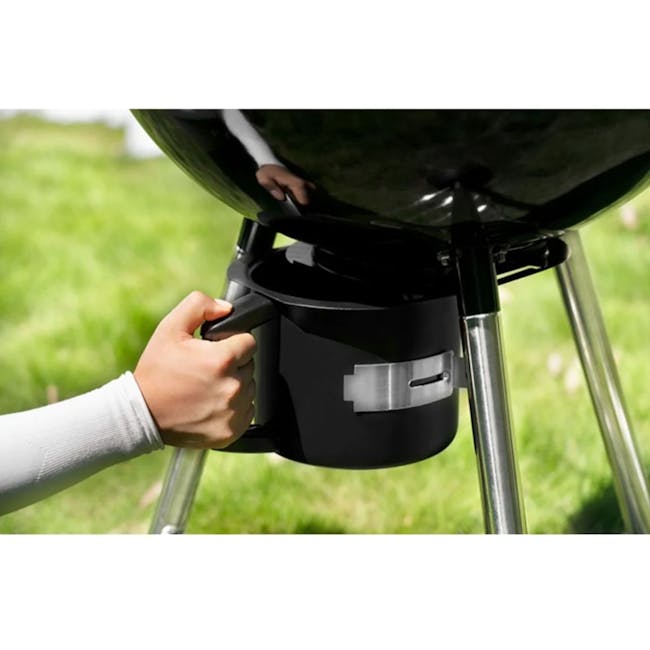 Flame Master Newton BBQ Grill - 7 - Grassy outdoor setting, person's hand, black bucket, outdoor cooking, grill, outdoor