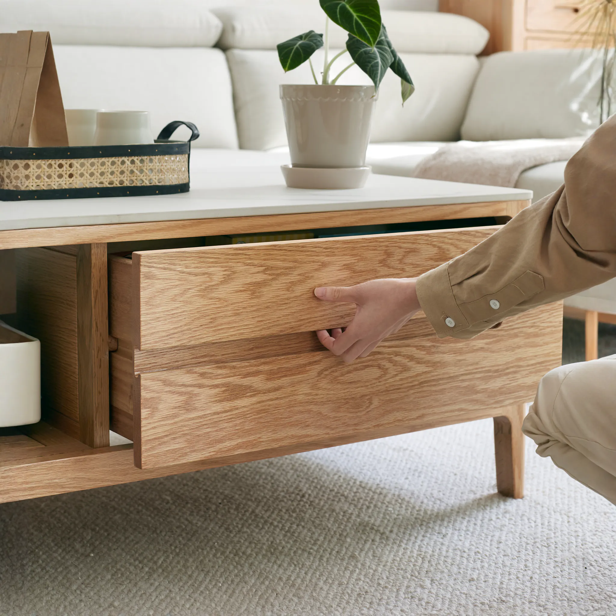 Devin Coffee Table 1m (Sintered Stone) - 13 - Wooden drawer, beige carpet, light brown wooden floor, beige pants, person's