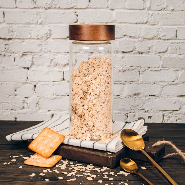 Table Matters Taikyu Acacia Clear Storage Jar (3 Sizes) - 5 - Glass jar filled with oats, white brick wall background